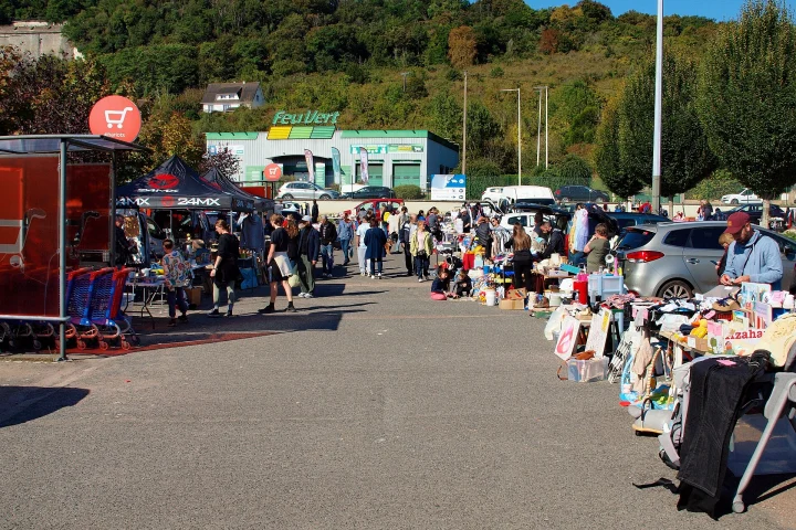 Vide-greniers sur un parking à Sens (Yonne) avec des étals d’objets et de vêtements d’occasion