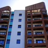 Façade d’un immeuble de logements collectifs avec balcons et bardage en bois