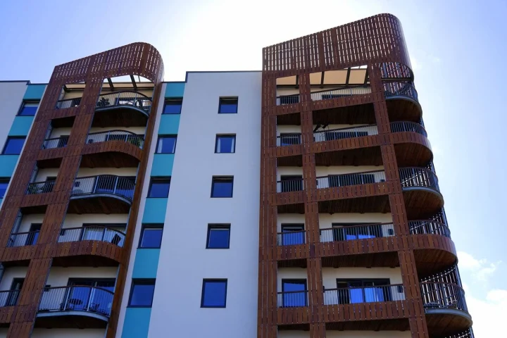 Façade d’un immeuble de logements collectifs avec balcons et bardage en bois