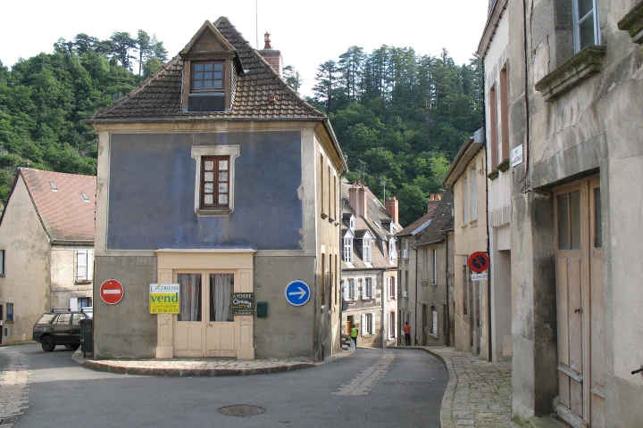 Maison de village avec un panneau à vendre sur la façade, à Aubusson (Creuse)