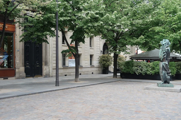 Place Saint-Germain-des-Prés dans le 6e arrondissement de Paris, sous les arbres, avec une statue sur la droite
