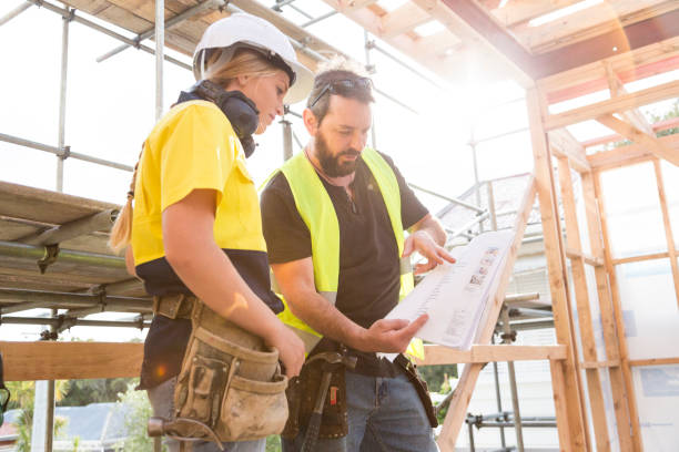 Deux constructeurs qui consultent un plan sur un chantier